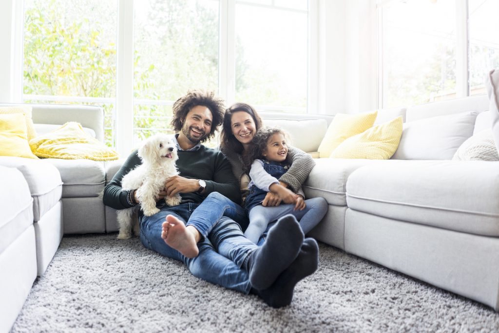 family sitting on couch with dog